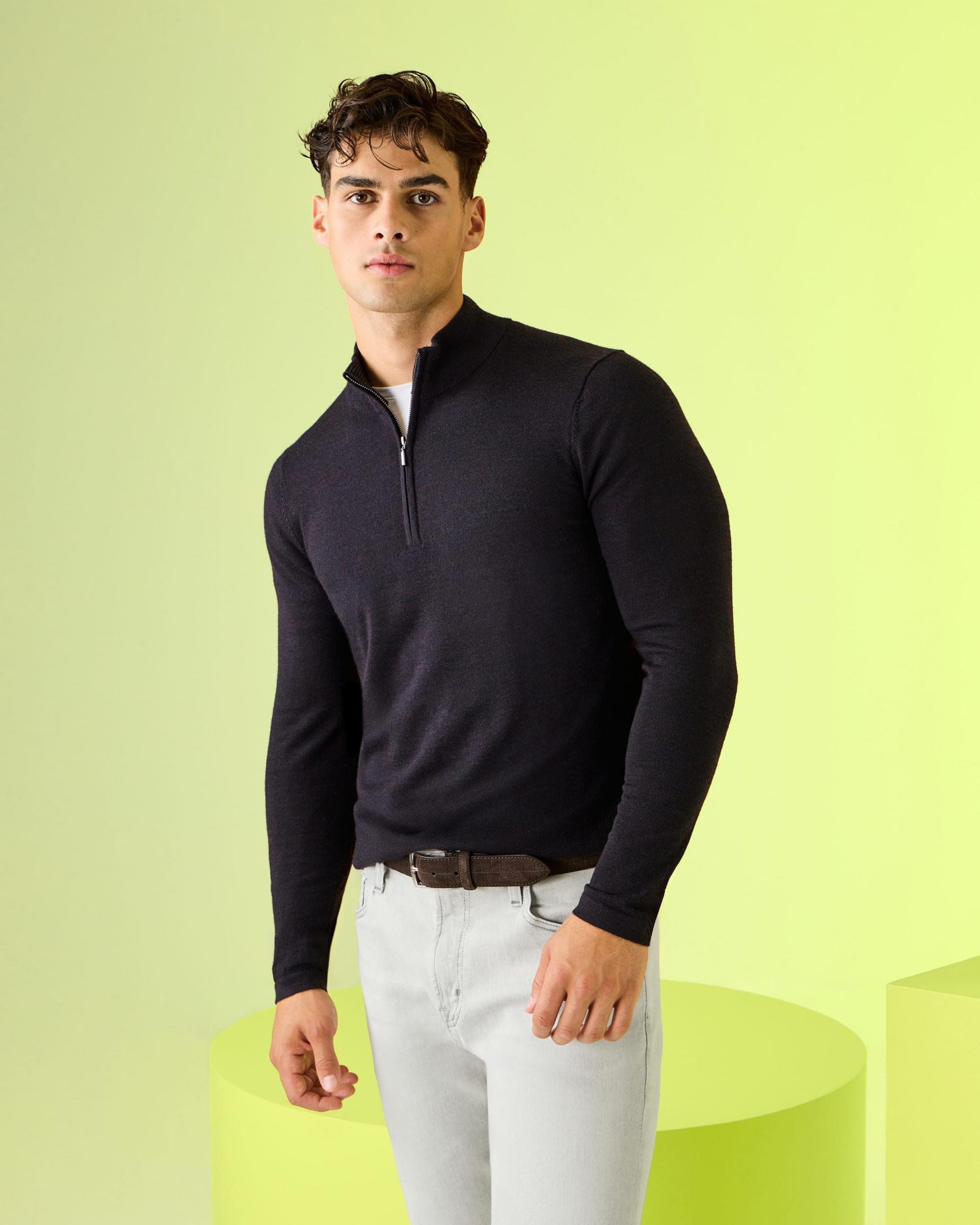 Des chandails Patrick Assaraf présentés sur un présentoir vert vif