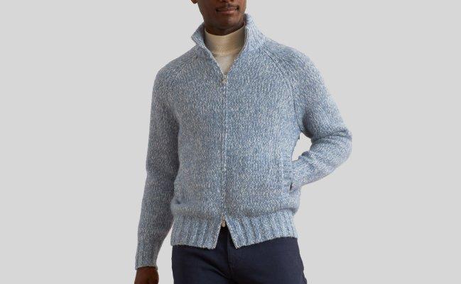Mannequin masculin portant un chandail en tricot à glissière complète bleu pâle Brunello Cucinelli, agencé à un col roulé écru et un pantalon bleu marine