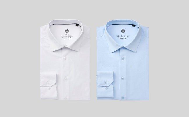 Une chemise habillée de performance blanche et bleu pâle présentée sur un fond gris