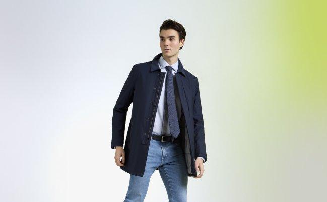 Model wearing a navy overcoat and tie with jeans