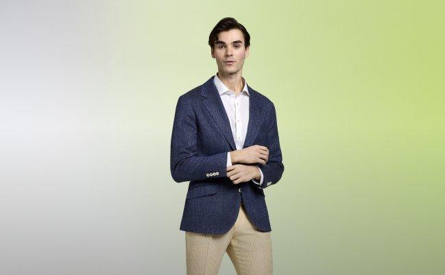 A model wearing a navy blazer and white dress shirt with khaki pants
