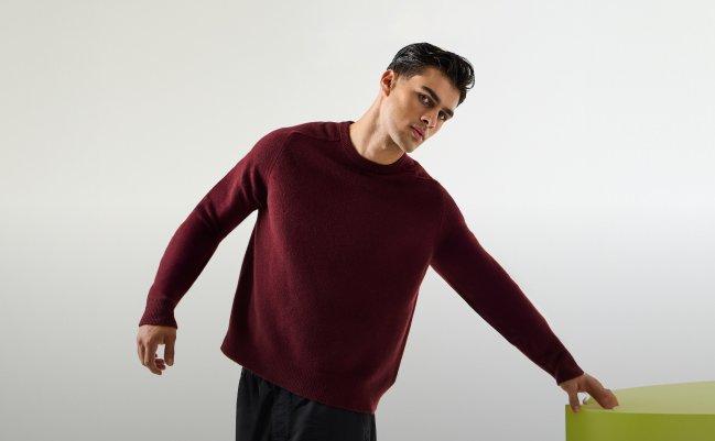 A model wearing a burgundy sweater