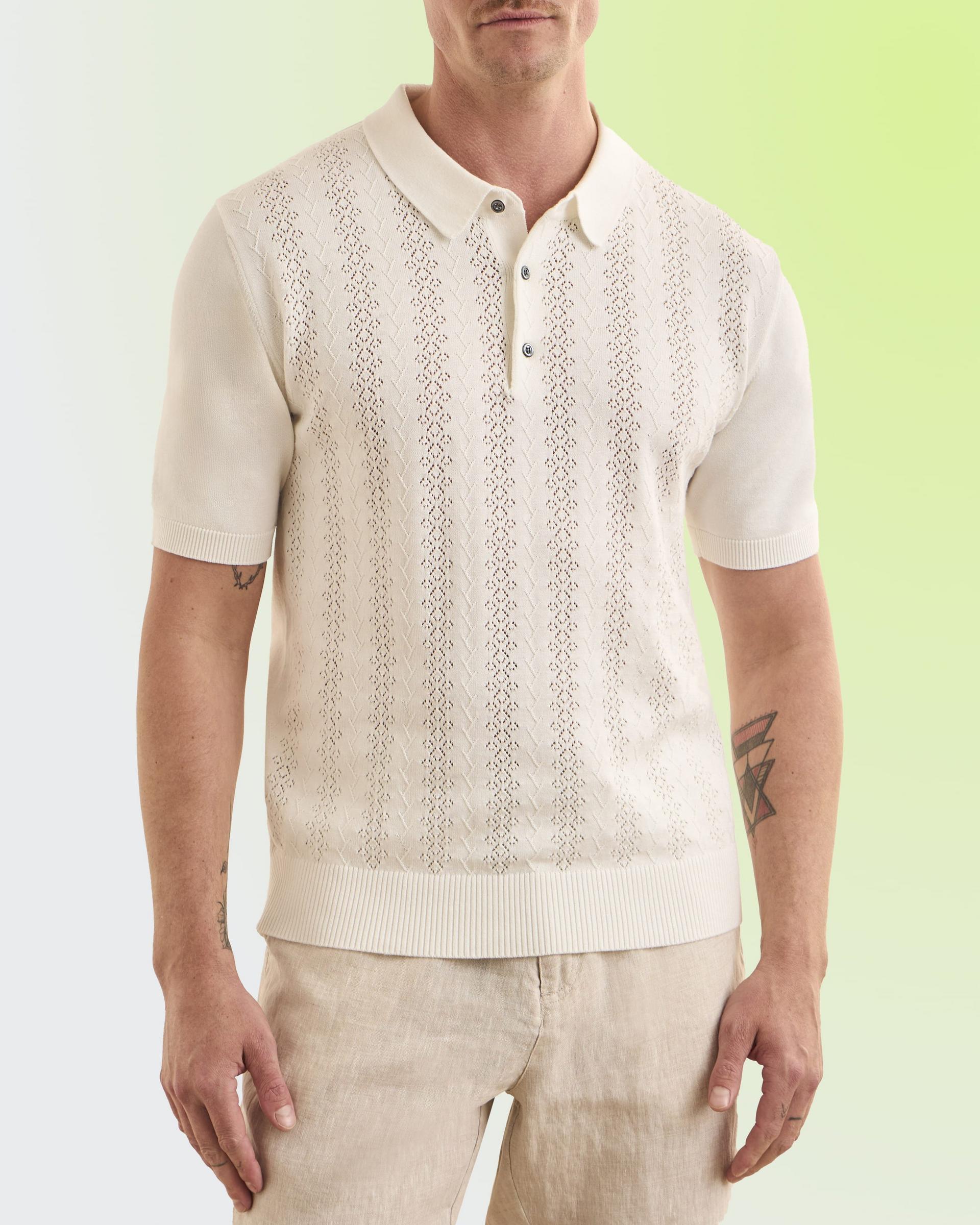 A man wearing an off-white polo t-shirt and pants