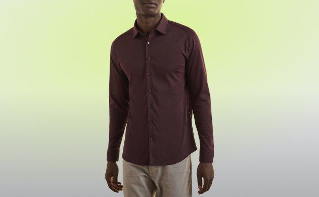 Un homme portant une chemise brun foncé et un pantalon blanc cassé