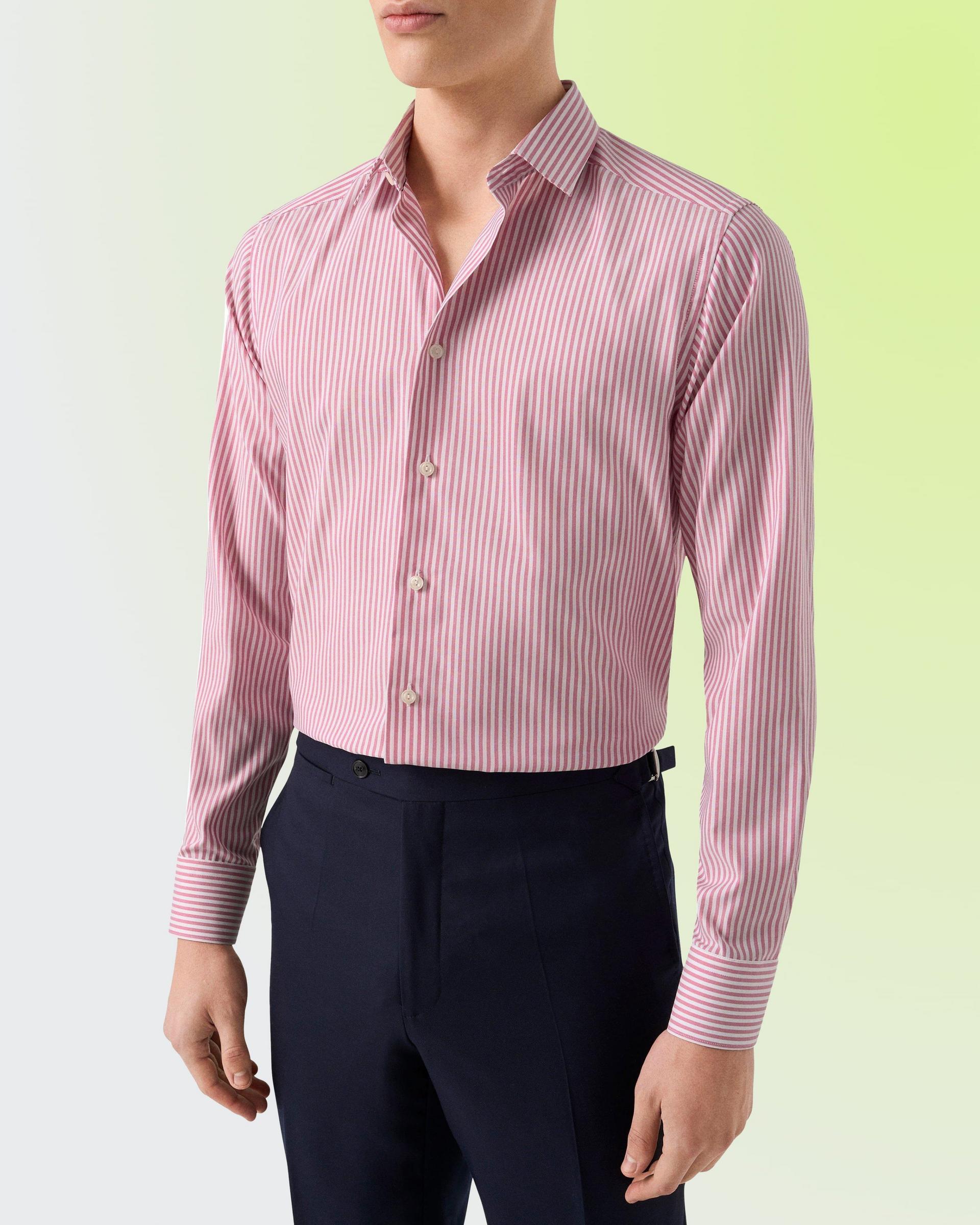 A man wearing a pink polo t-shirt with light brown pant