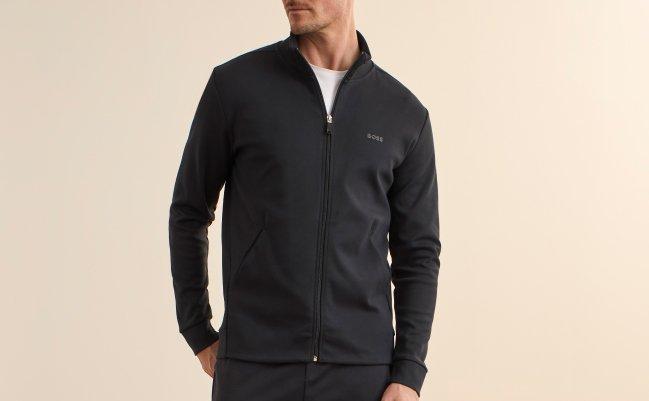 A model wearing an all-black BOSS sweatsuit