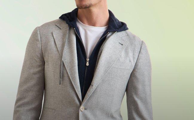 Mannequin masculin portant un chandail en tricot à glissière complète bleu pâle Brunello Cucinelli, agencé à un col roulé écru et un pantalon bleu marine