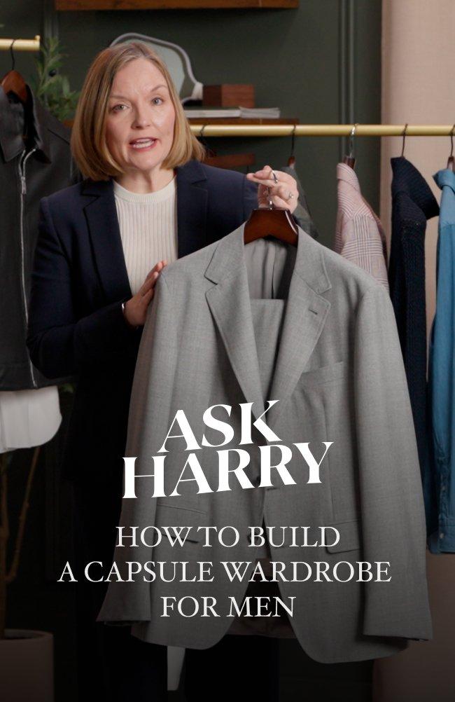 An associate holding a light gray suit jacket on a hanger and overlaid text reads "ASK HARRY – HOW TO BUILD A CAPSULE WARDROBE FOR MEN"