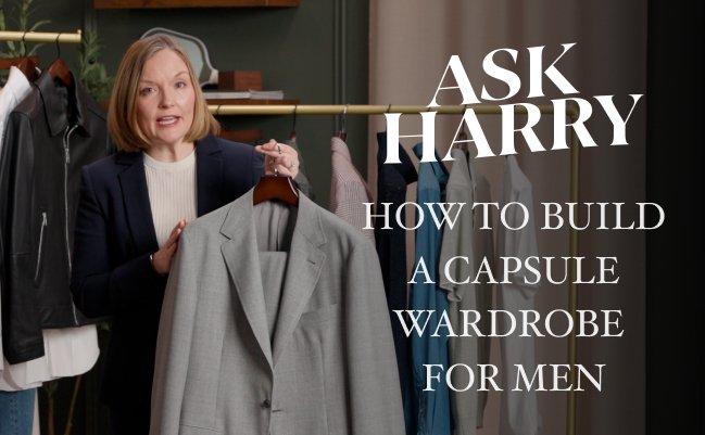 An associate holding a light gray suit jacket on a hanger and overlaid text reads "ASK HARRY – HOW TO BUILD A CAPSULE WARDROBE FOR MEN"