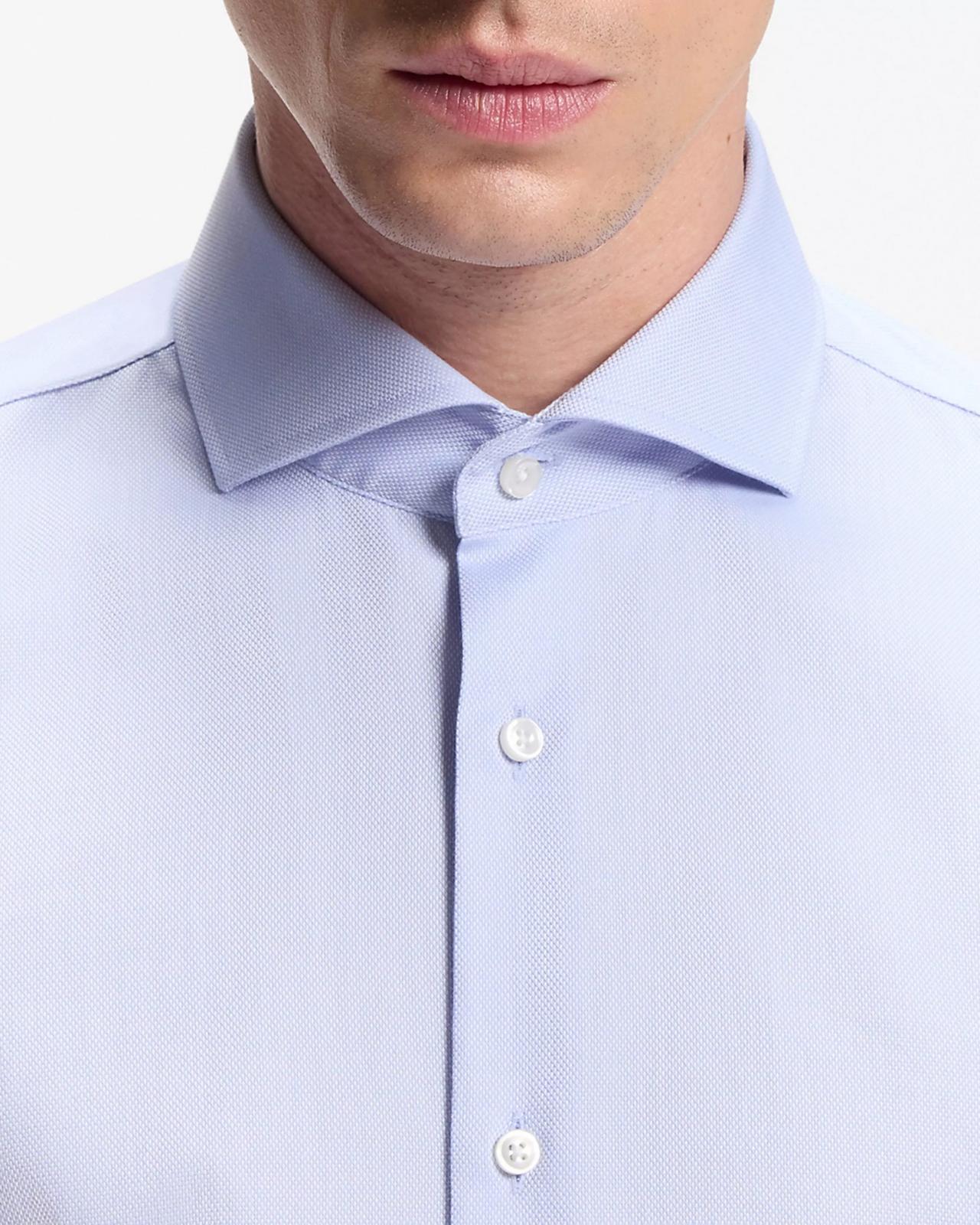 close-up of a model wearing a light blue dress shirt with a cutaway collar