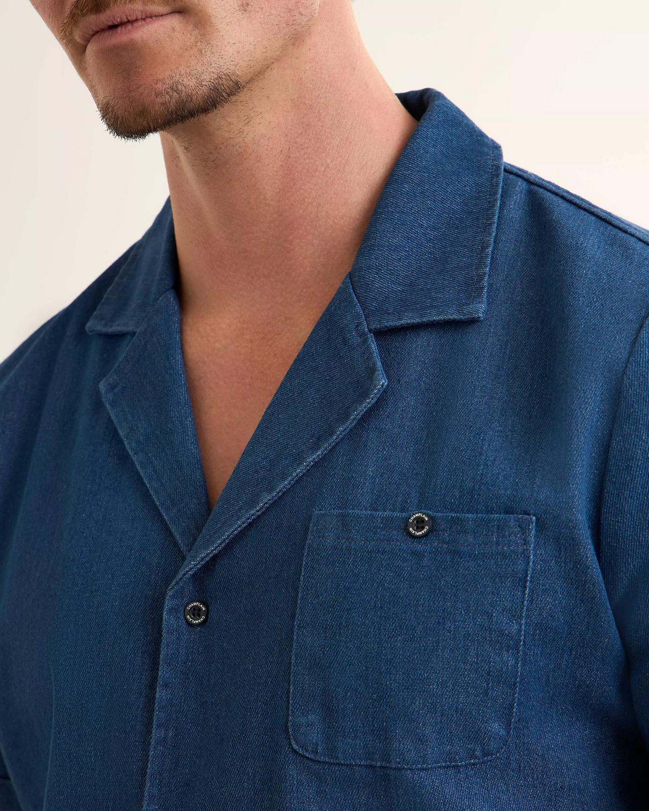 close-up shot of model wearing a navy blue linen shirt with camp collar