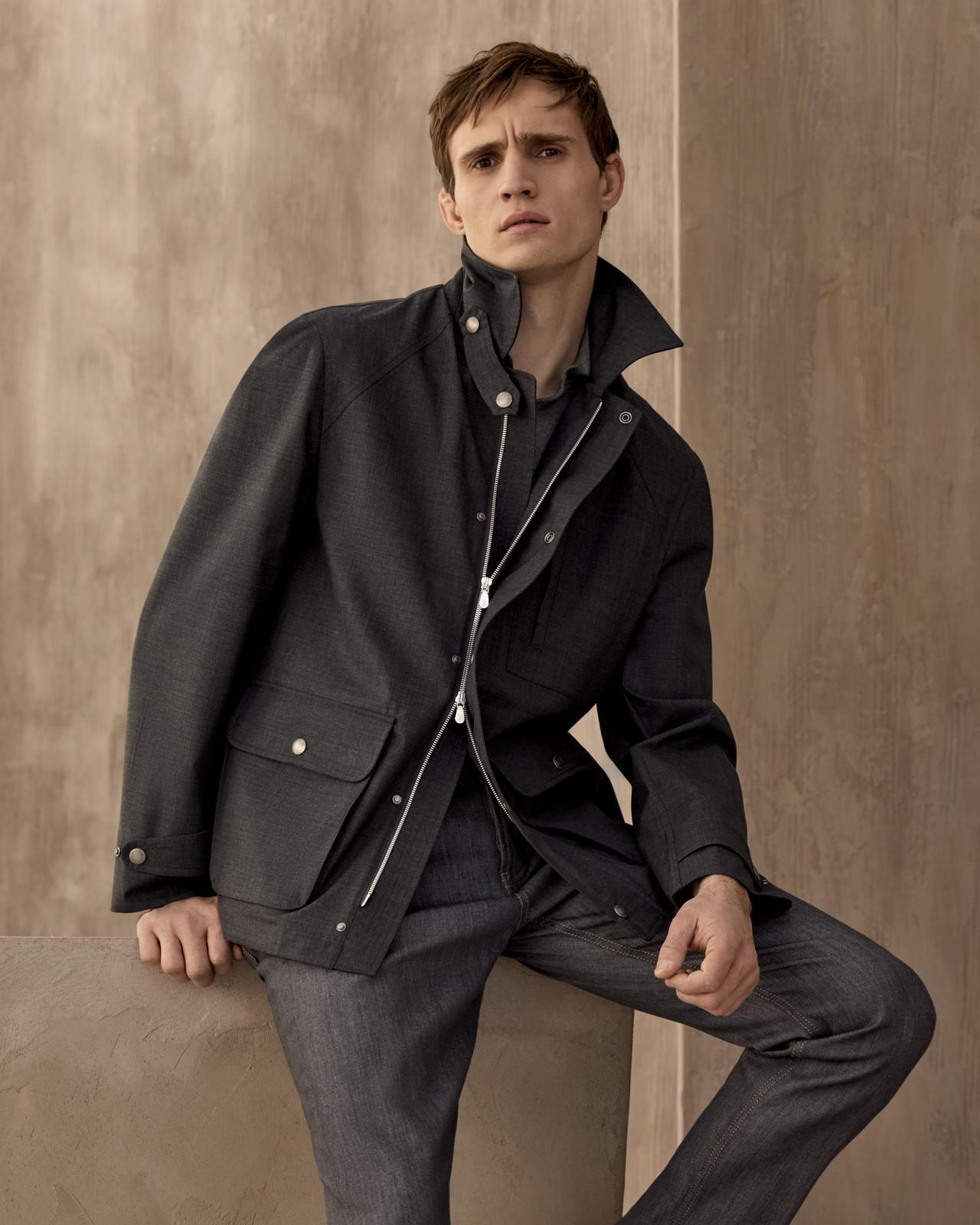 Mannequin portant une veste noire résistante à l’eau de Brunello Cucinelli, avec polo en maille et pantalon noir