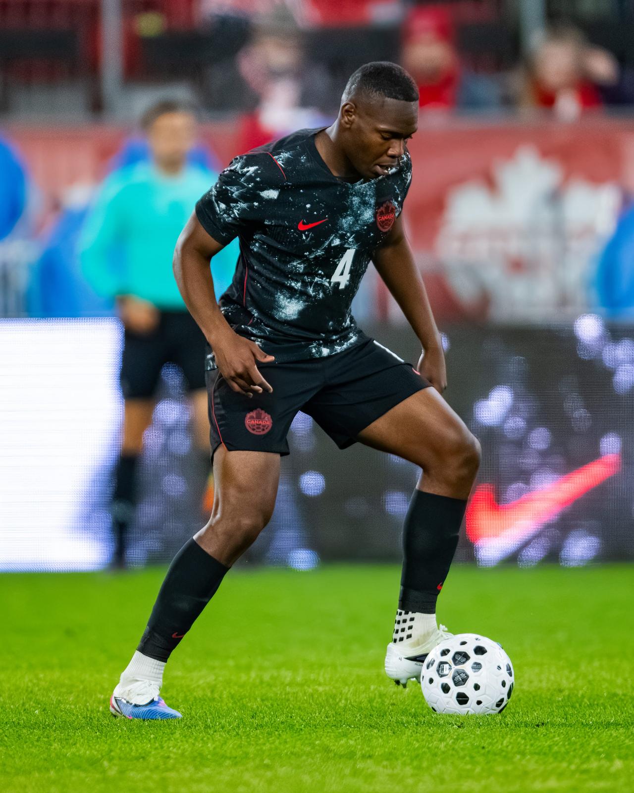 Kamal Miller Canadian Soccer Player wearing sportswear with red and white Canada written Scarf