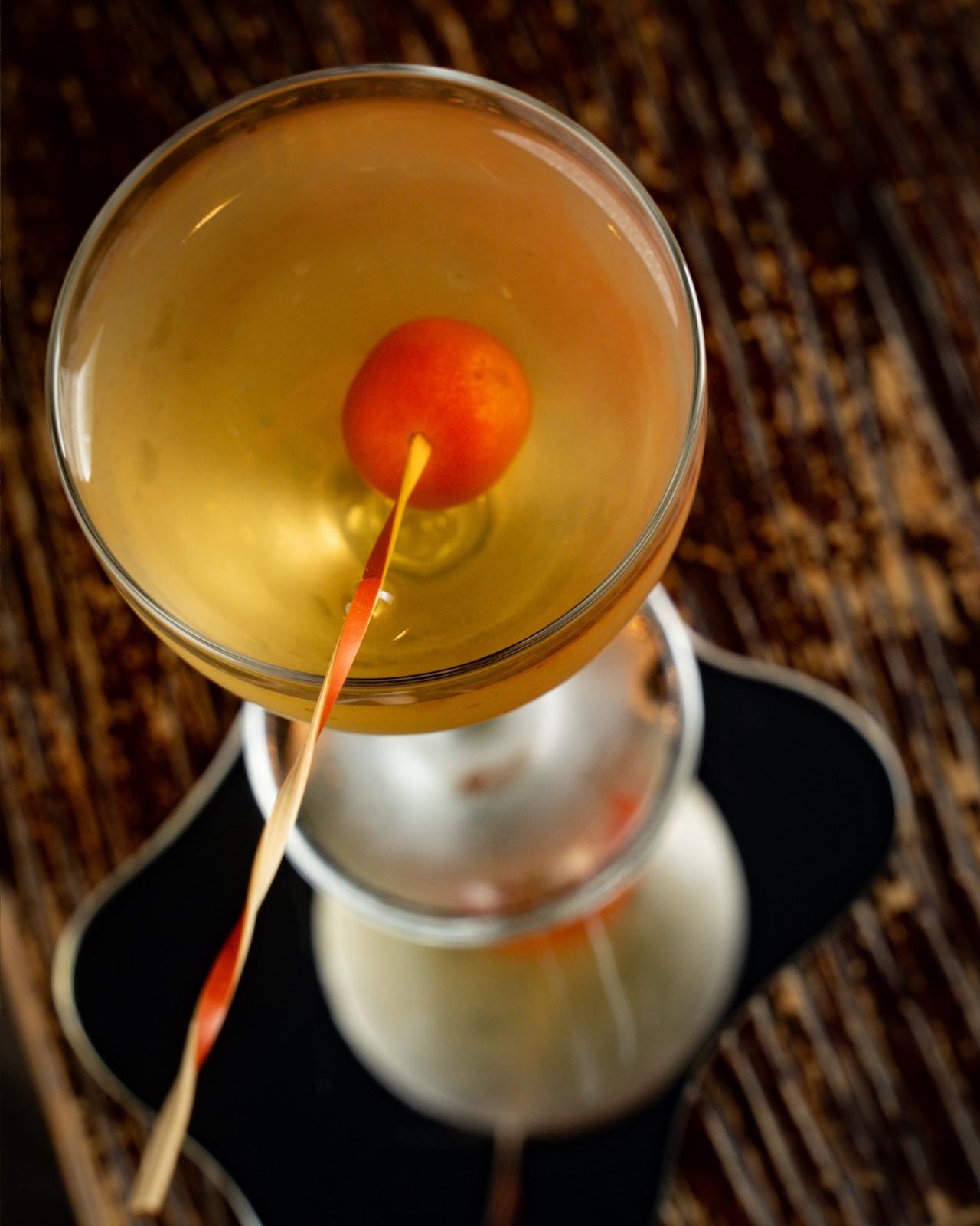 Rob Roy Cocktail served in a coupe glass, garnished with a single maraschino cherry on a thin stick