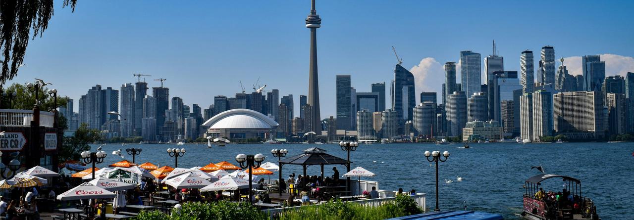 Toronto Skyline as seen from across the water, with the iconic CN Tower rising above the city's modern high-rises