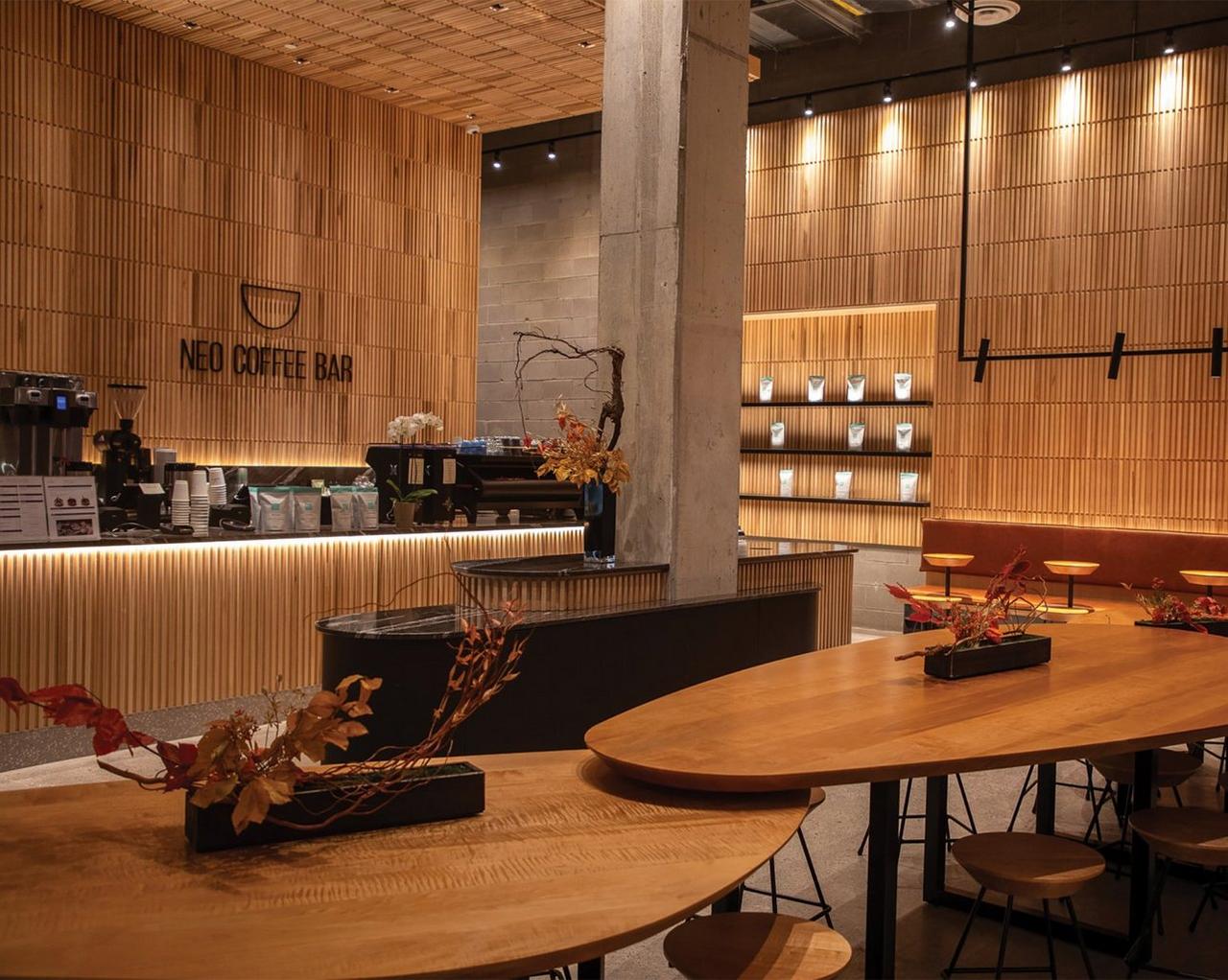 Neo Coffee Bar, avec ses boiseries chaleureuses, ses sièges minimalistes et son comptoir élégant équipé de matériel de préparation du café