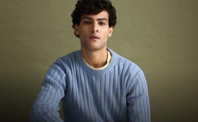 A man wearing a light blue sweater