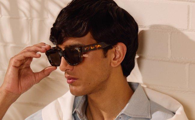 A man wearing round black sunglasses