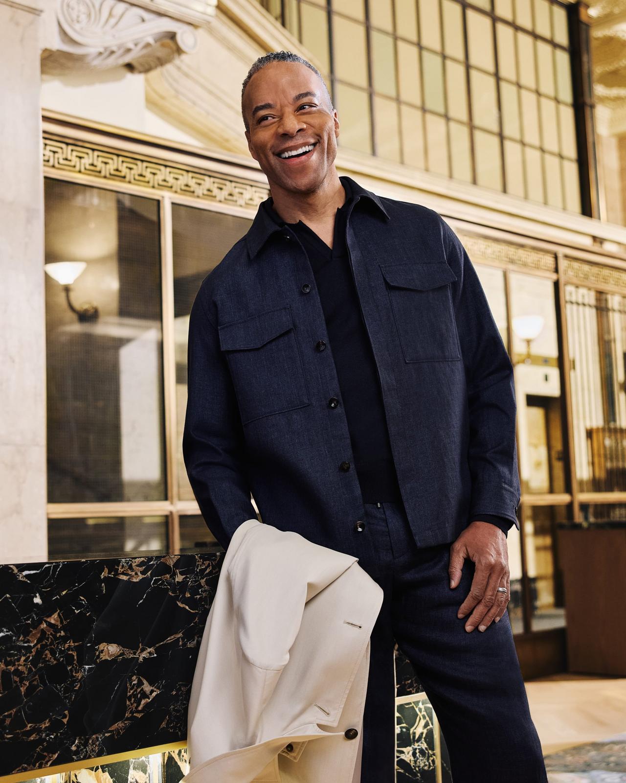 Male model wearing a navy Agnona overshirt styled with a black shirt and black pants