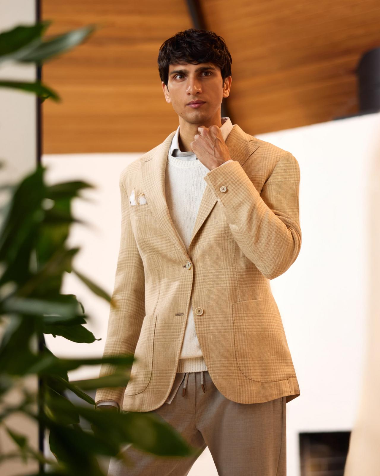 Male model wearing a cream Eleventy jacket styled with a polo shirt