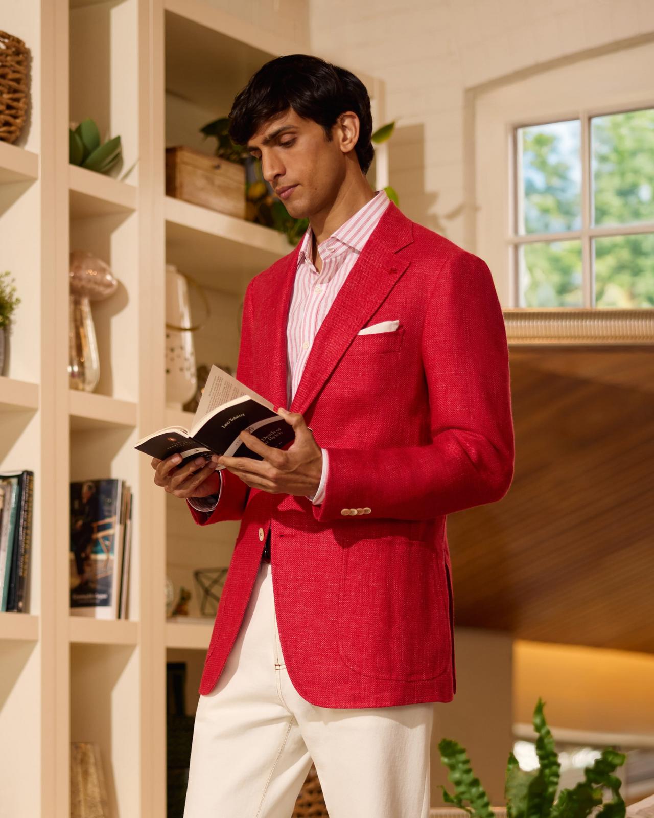 Mannequin masculin portant une veste rouge vif Isaia, agencée à un pantalon blanc et des mocassins en suede brun