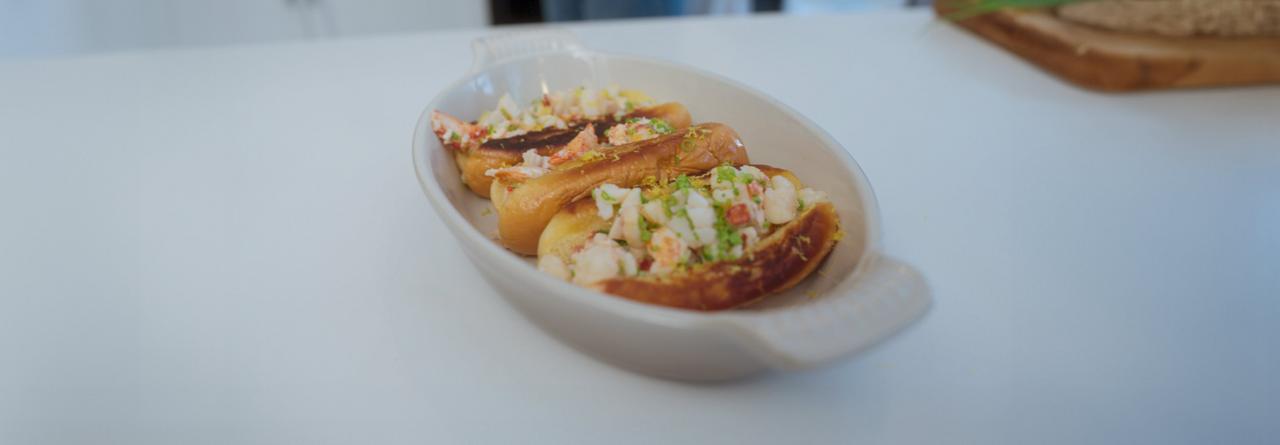 Lobster rolls presented on a white oval platter