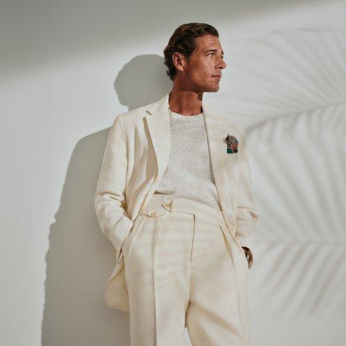 Un homme portant un costume blanc cassé avec un t-shirt à col rond