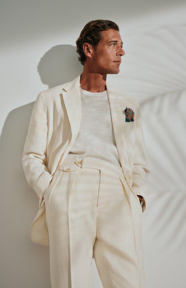 A man wearing an off-white suit with crewneck t-shirt