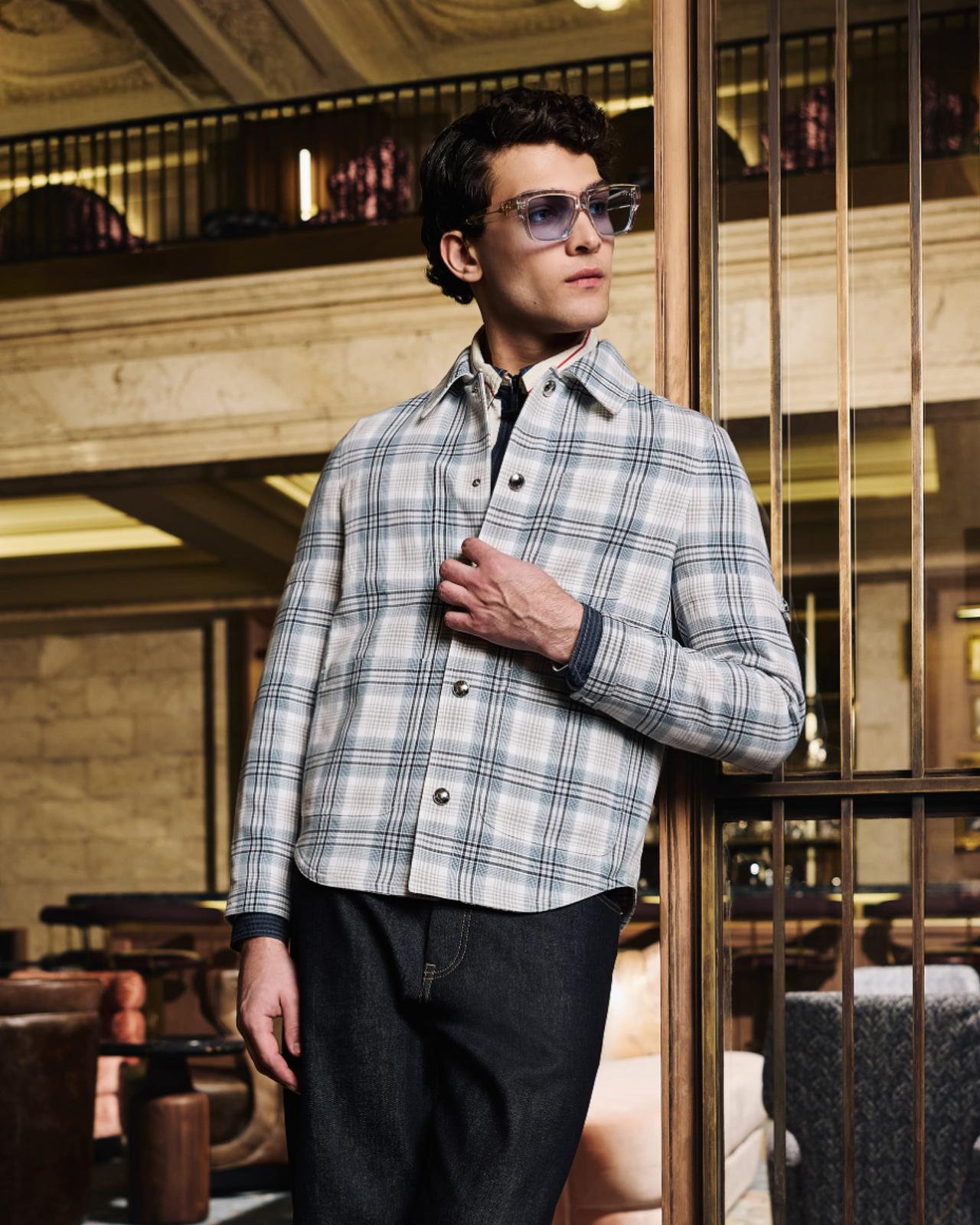 A man wearing an off-white check patterned shirt with black pant