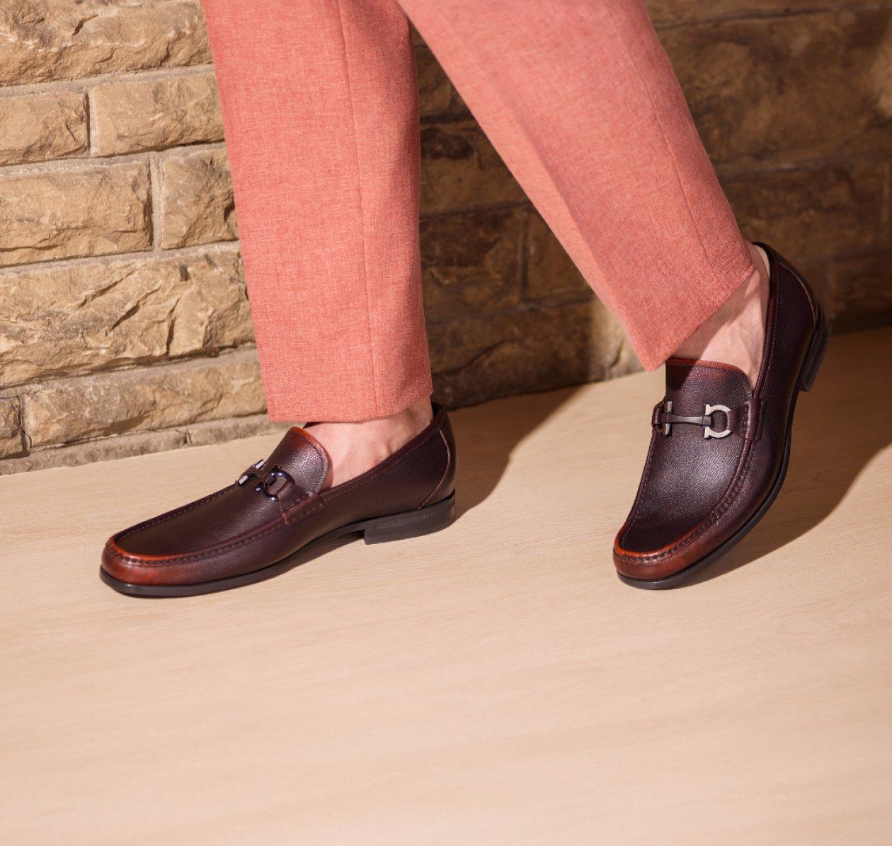 A man wearing a muted brown loafer