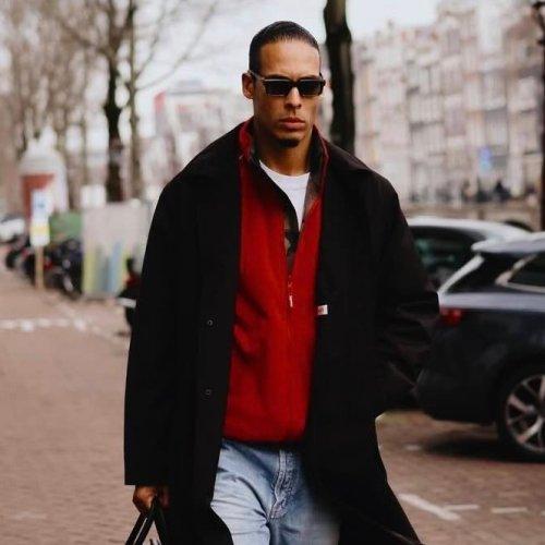 Virgil van Dijk wearing a black coat layered over a red and white athletic-style top