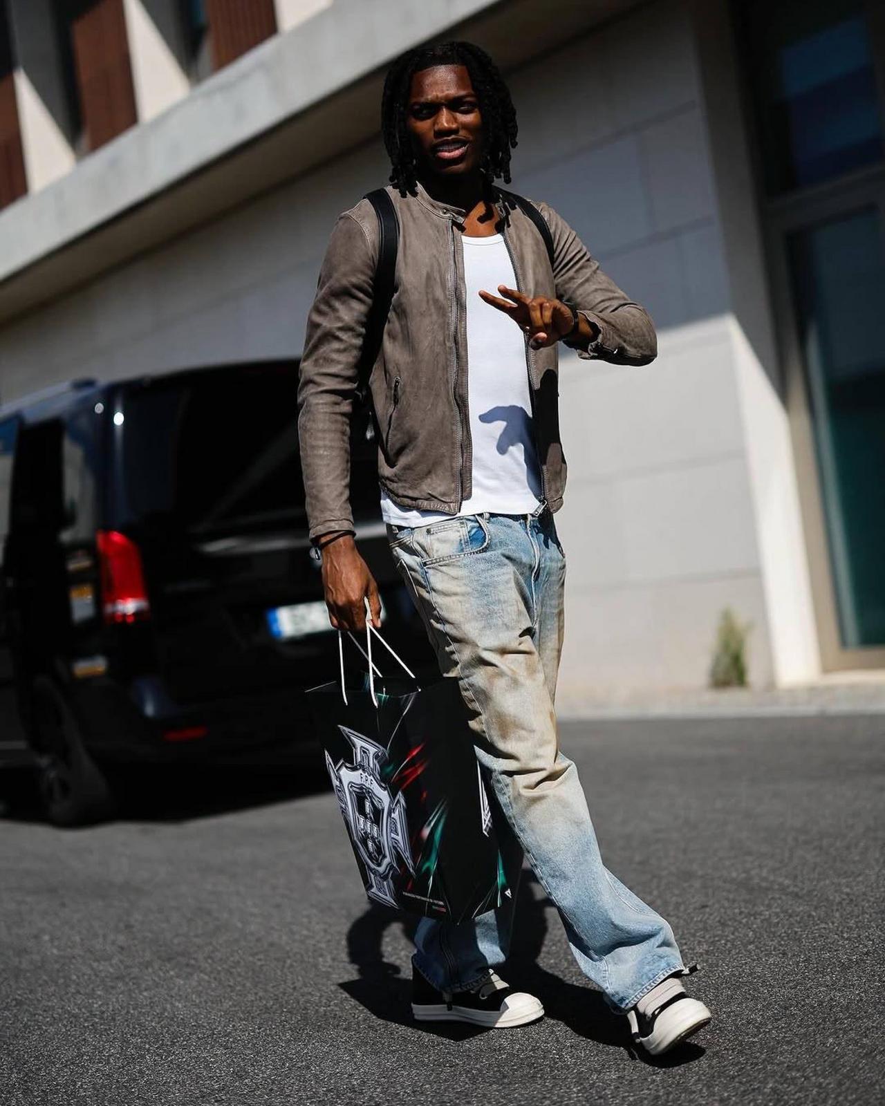 Rafael wearing a lightweight leather jacket with denim and two-tone sneakers