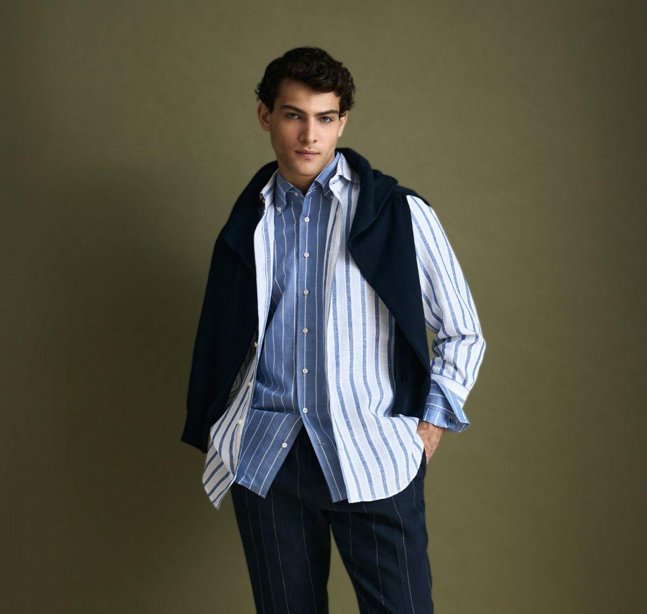 A man wearing a Navy Blue vest with white and blue striped pattern shirt