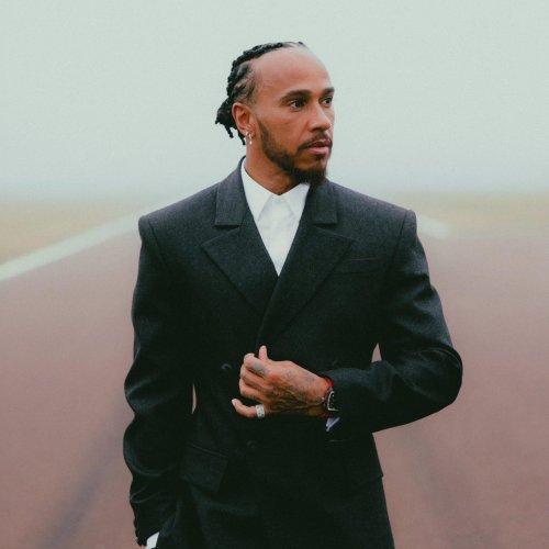 A man wearing a black suit with white shirt