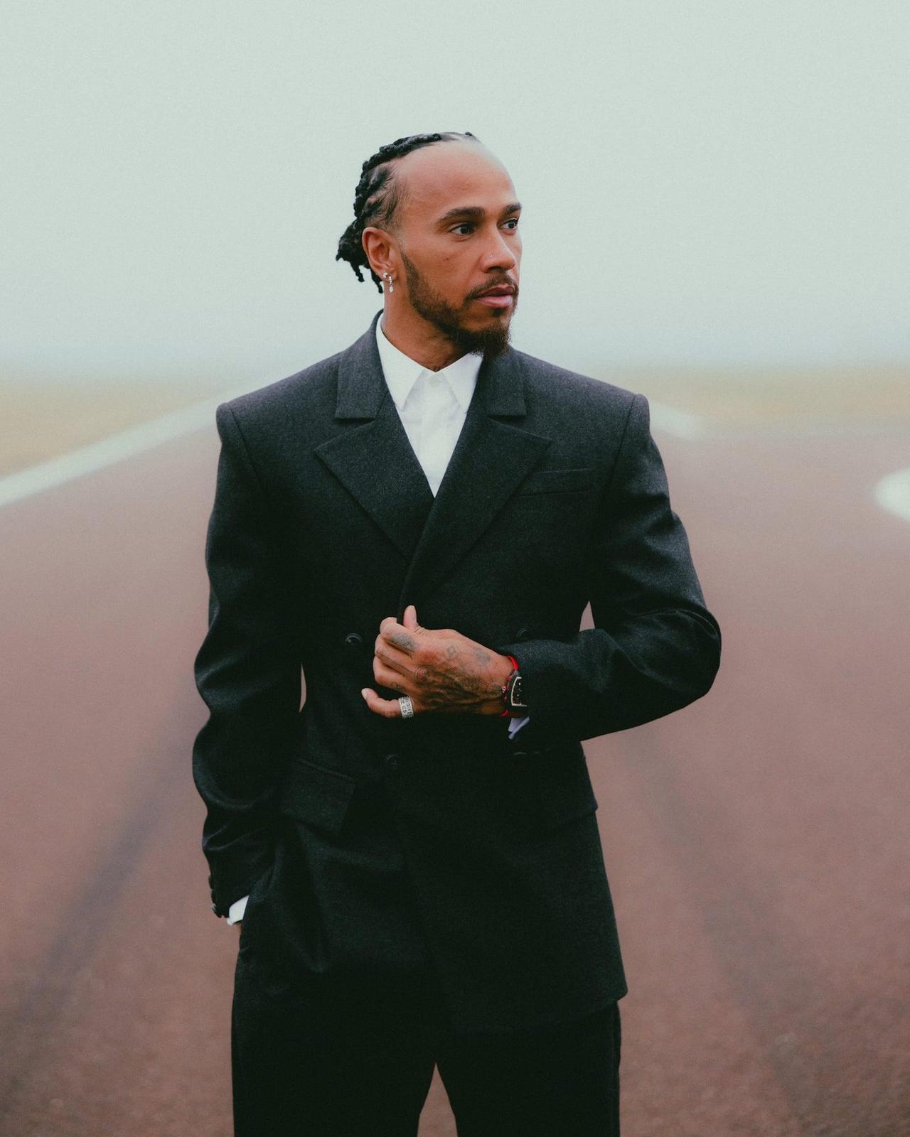 Lewis Hamilton portant un complet noir avec une chemise blanche
