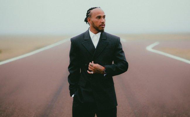 A man wearing a black suit with white shirt