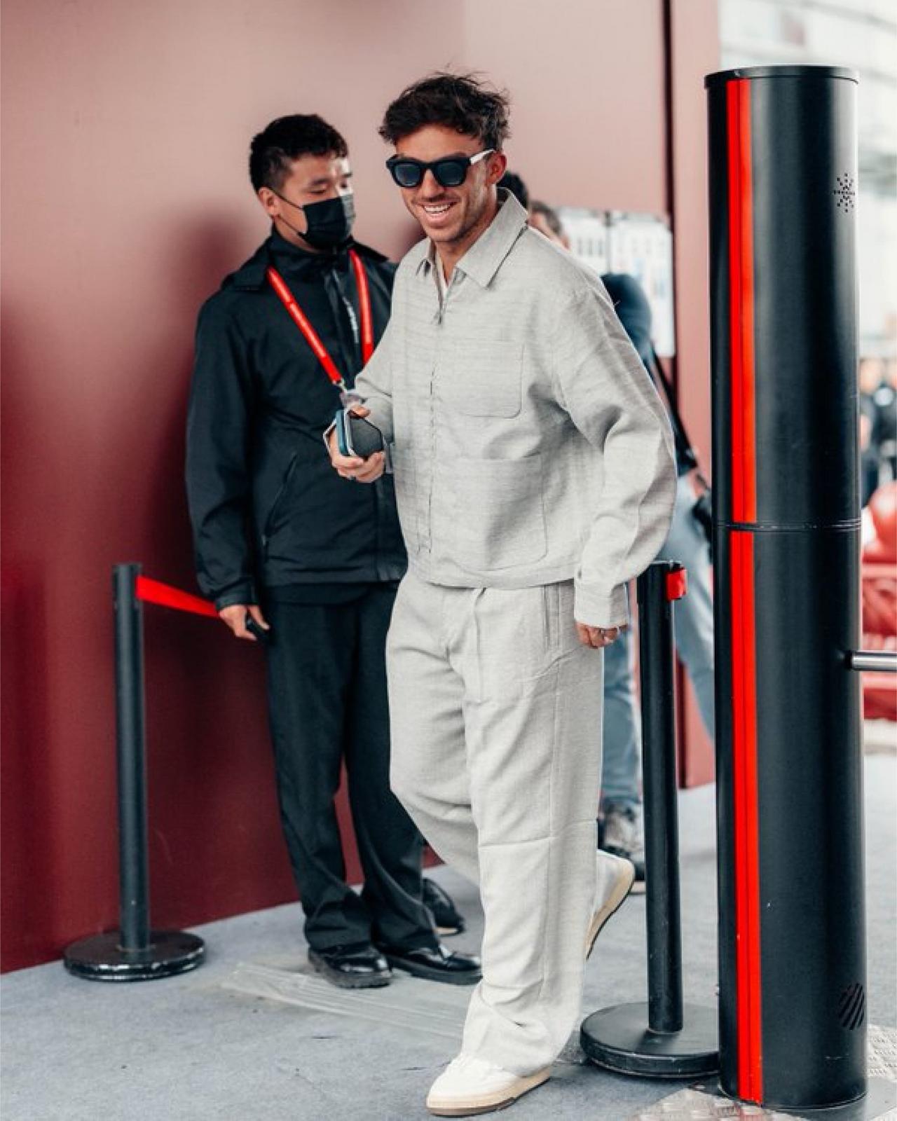 Pierre Gasly portant une surchemise gris pâle avec un pantalon crème et des mocassins