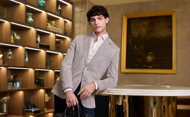 A man wearing a light grey blazer with cream shirt