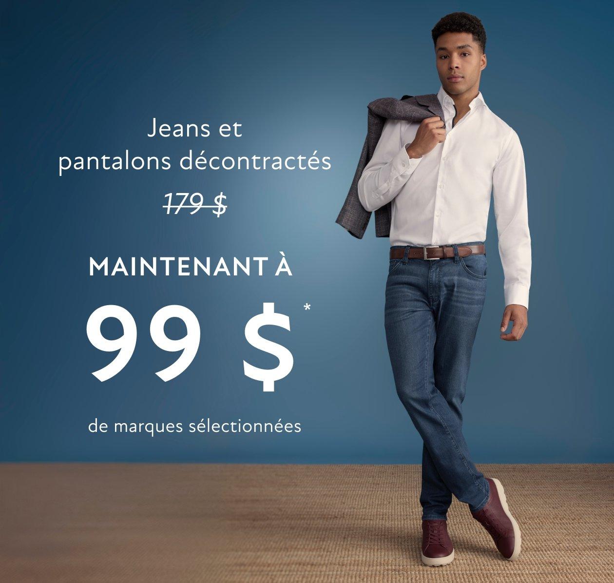 Un homme portant une chemise blanche et un jean bleu foncé avec des baskets brunes