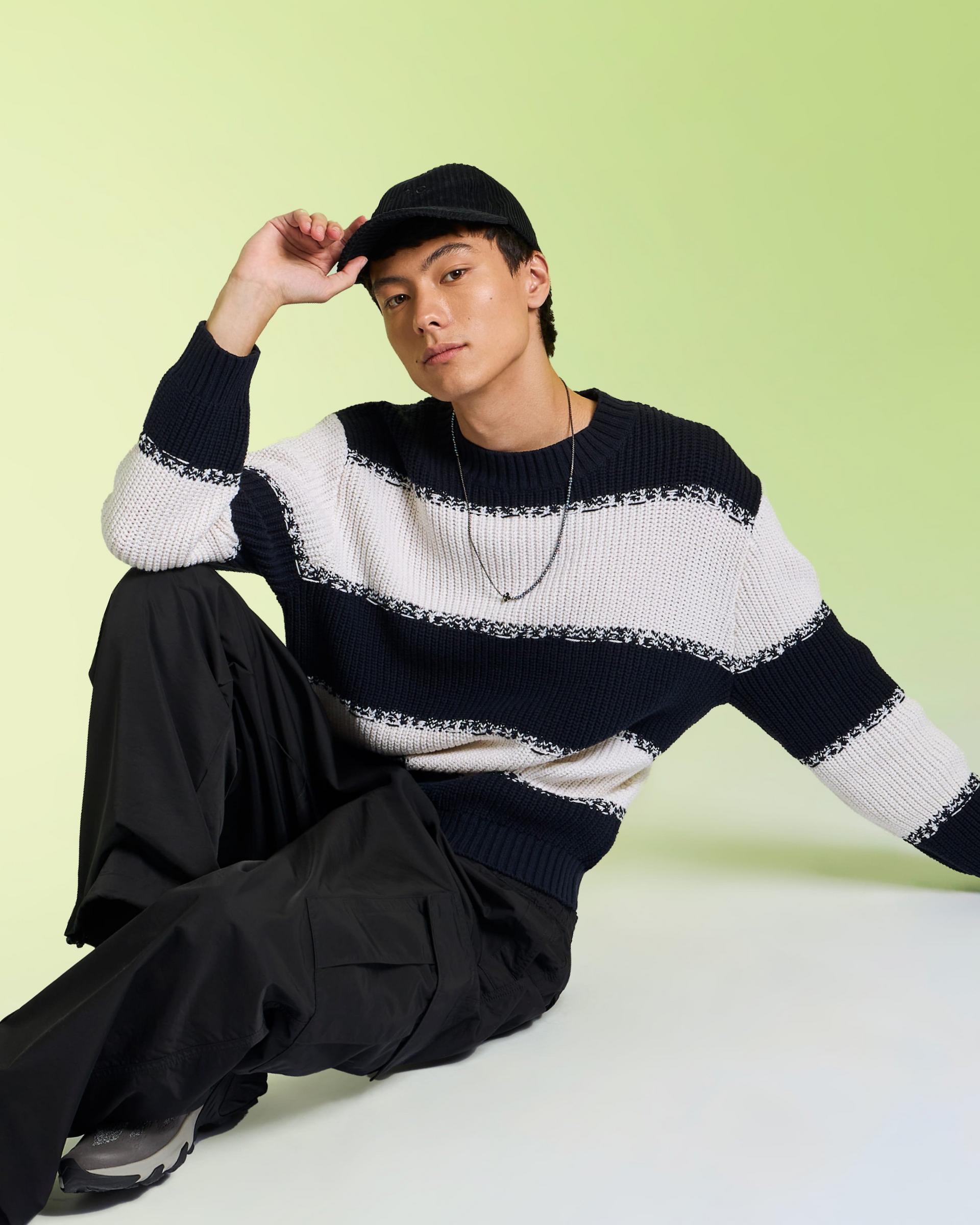 A male model wearing a knit sweater