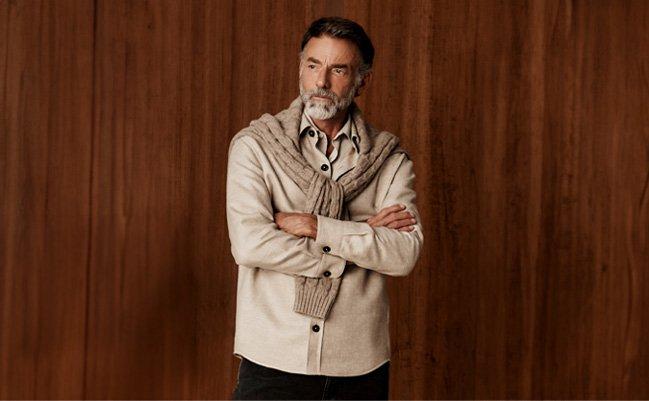 A man wearing a beige color shirt with light mocha sweater