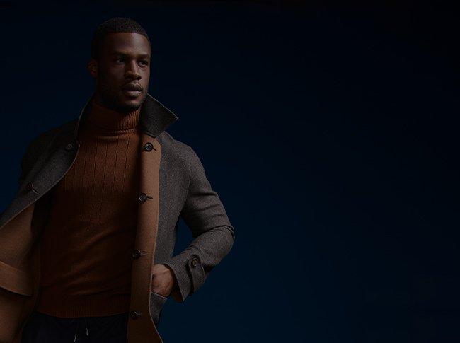 Man modelling orange turtleneck sweater and grey/camel reversible wool casual jacket.