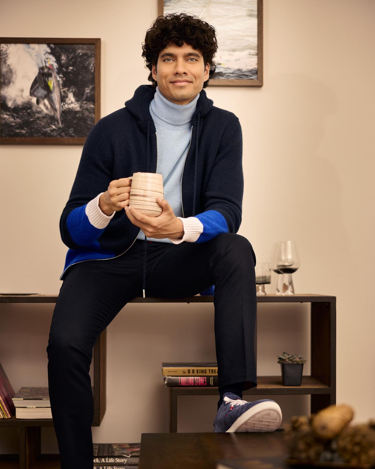 Male model sitting enjoying coffee wearing Kiton illustrating winter & ski