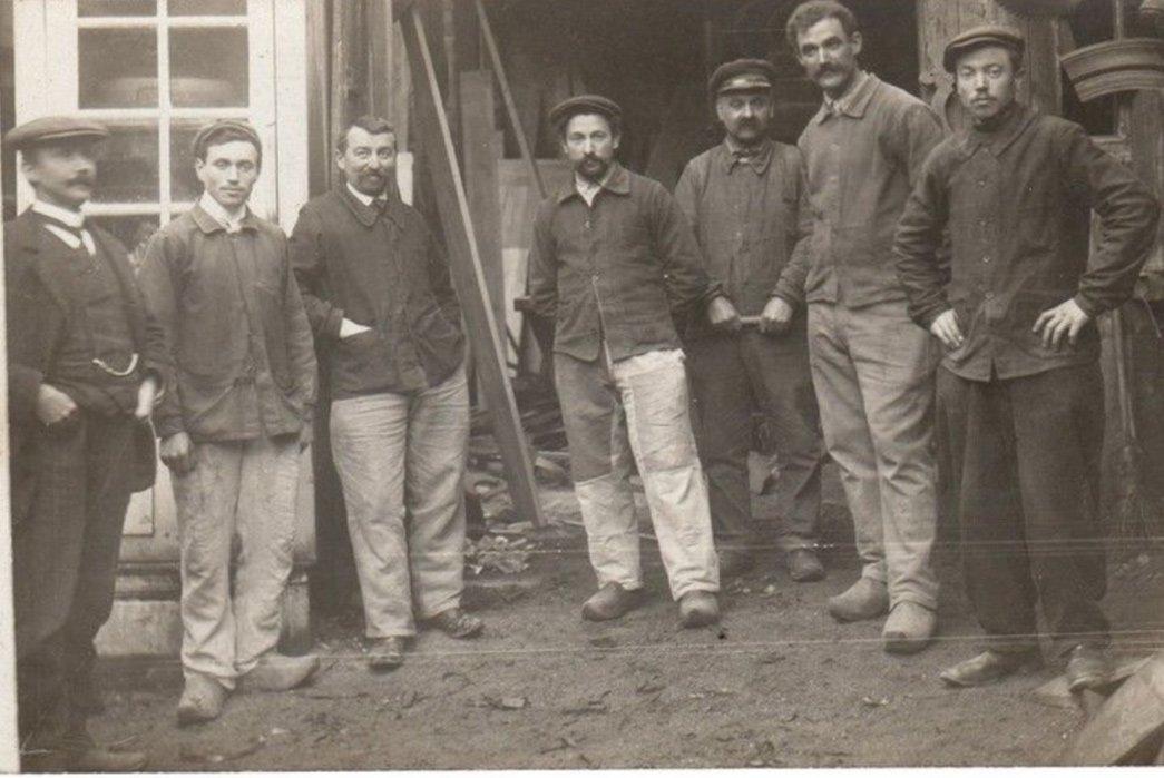 Black and white photo of men in classic chore coats