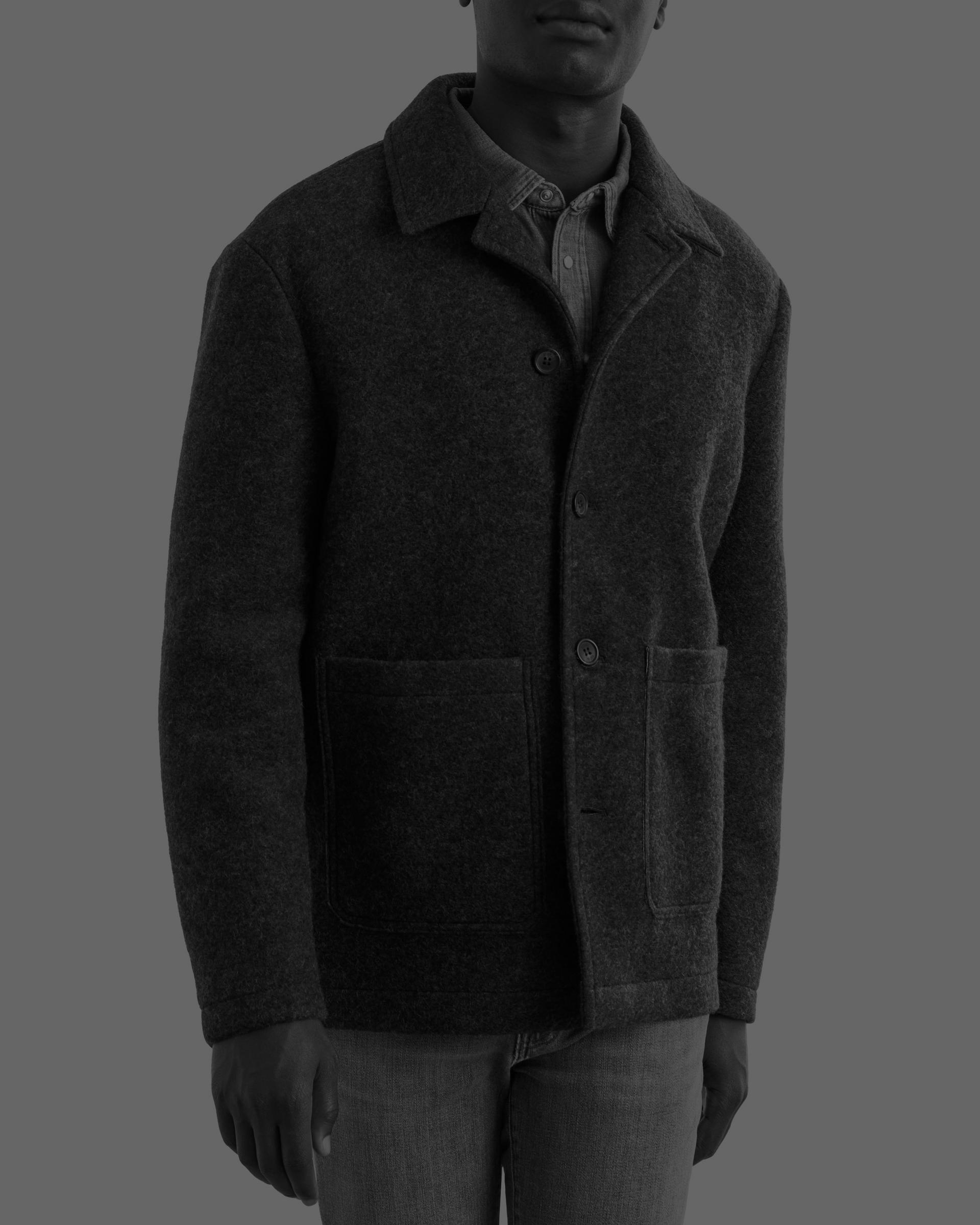 A man wearing a soft jacket layered over a denim casual shirt