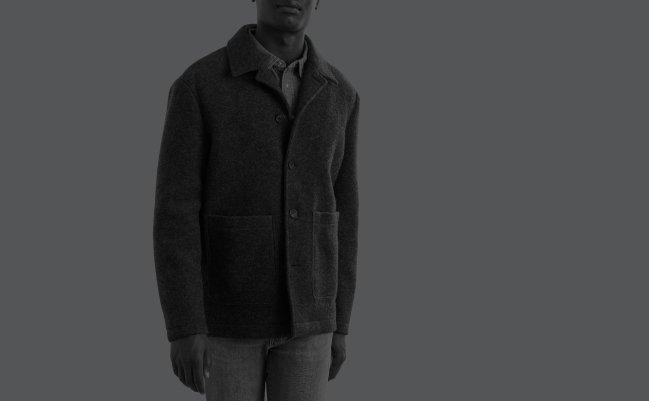 A man wearing a soft jacket layered over a denim casual shirt