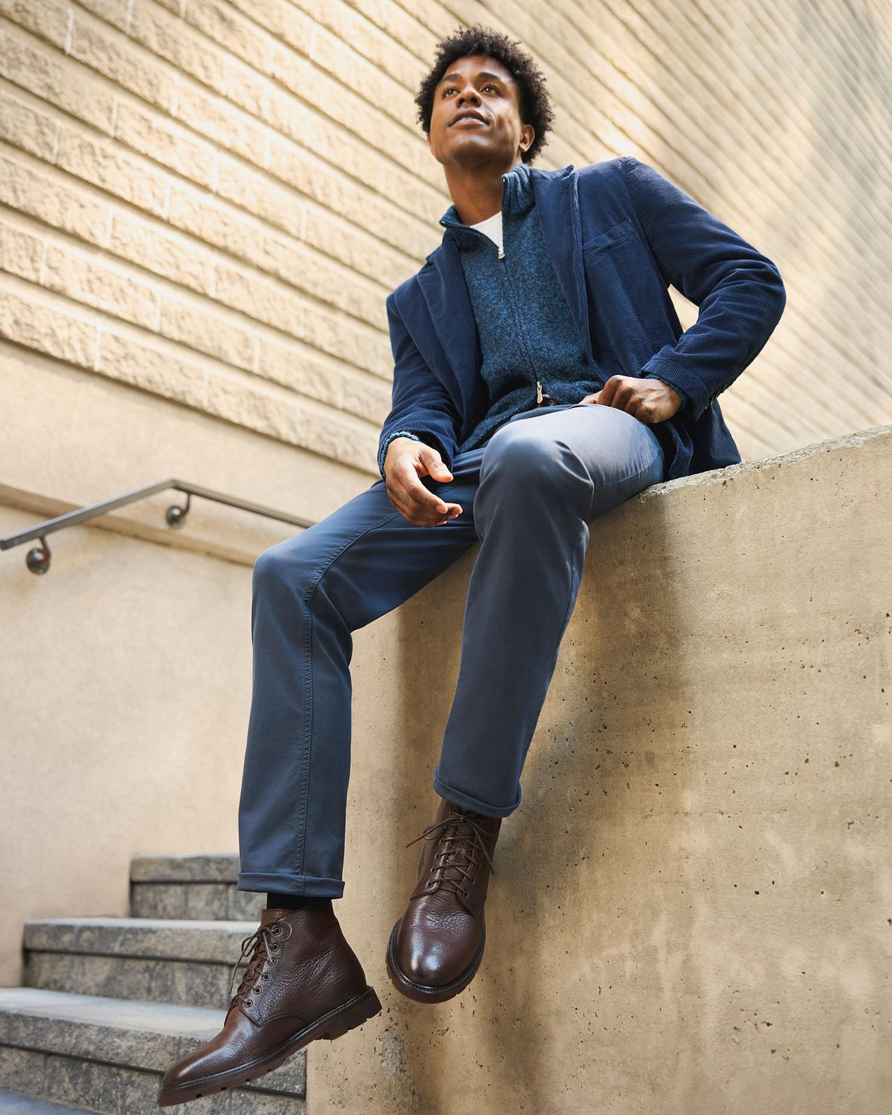 Man wearing a blue cardigan and pants layered over a matching blue jacket for an all-blue outfit