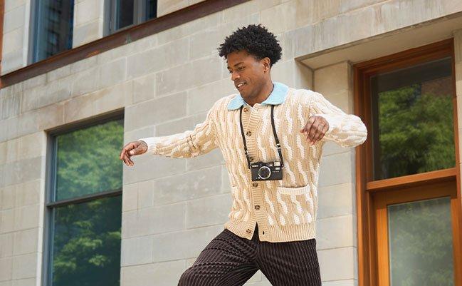 Un homme portant un cardigan beige avec un pantalon brun et des chaussures décontractées beiges