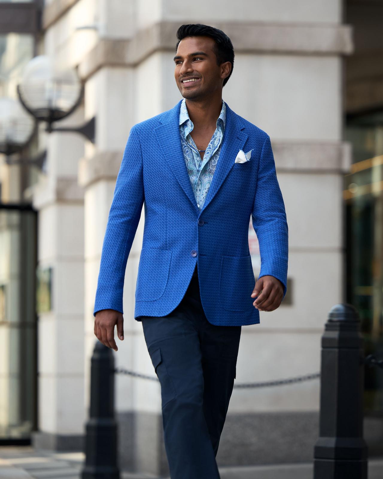 Un homme portant une veste sport bleue avec un jean en denim et une chemise bleu pâle