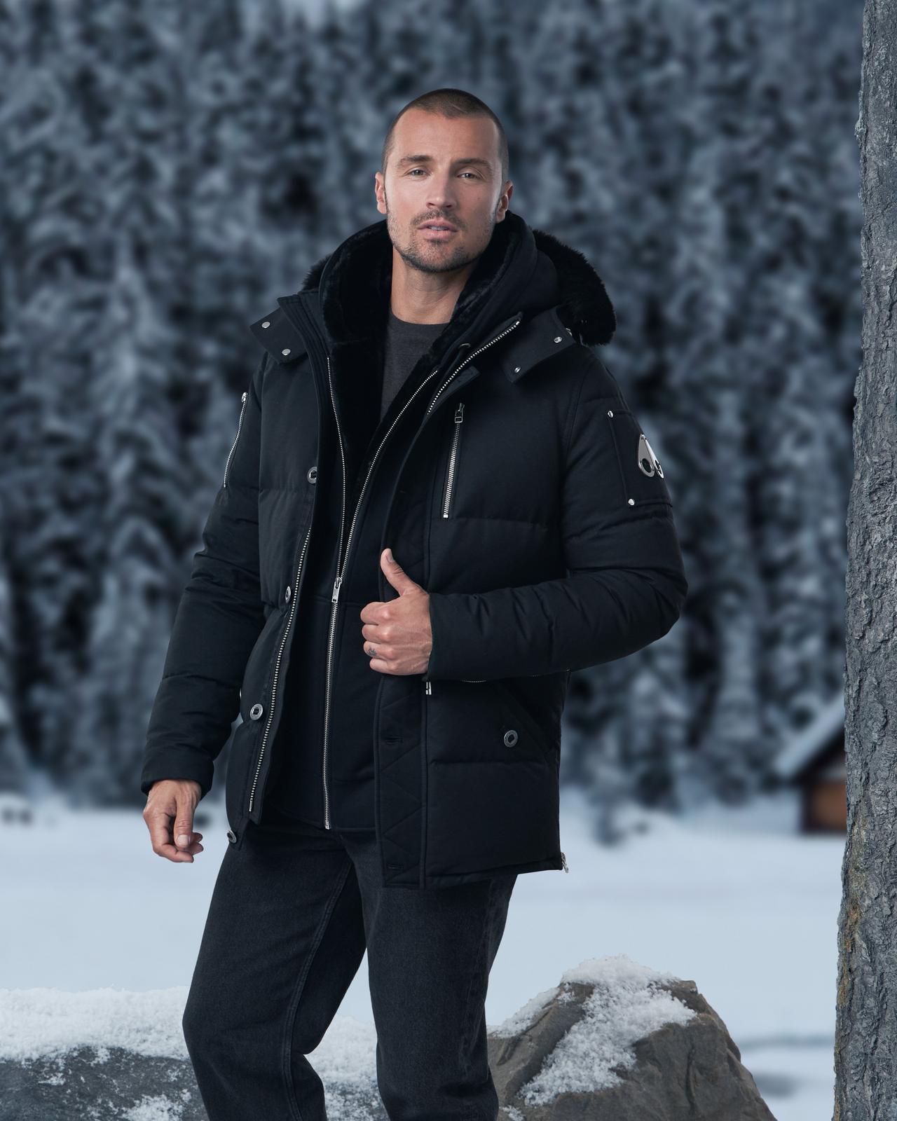 Modèle masculin portant un parka Moose Knuckles signifiant manteaux et vestes pour temps froid